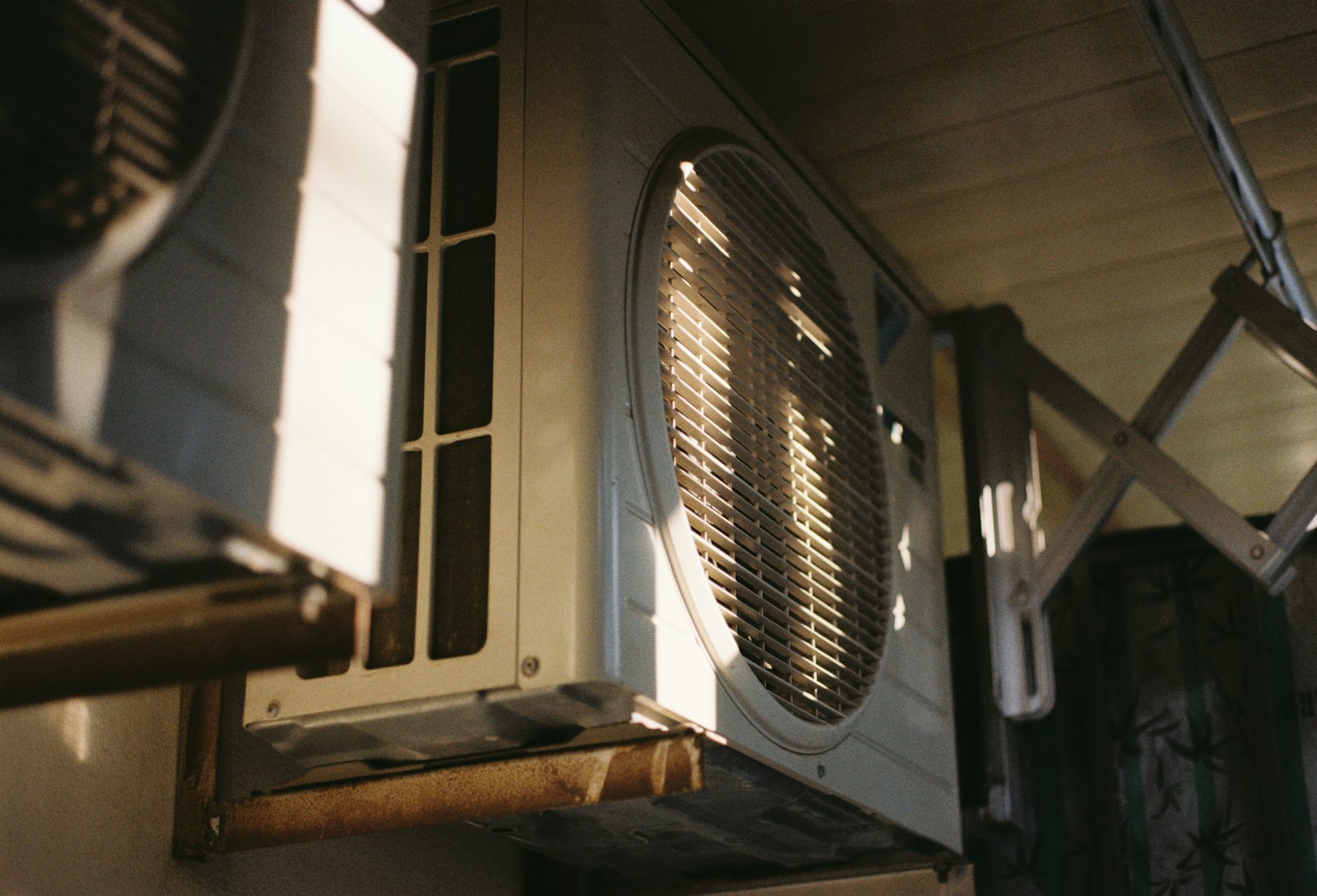 Close view of an outdoor air conditioning unit beside a house